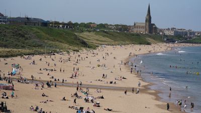 People enjoy the warm weather on Tynemouth Longsands beach, near Tynemouth in Tyne and Wear.