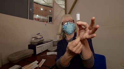 Woman drawing vaccine at Jersey's vaccination centre