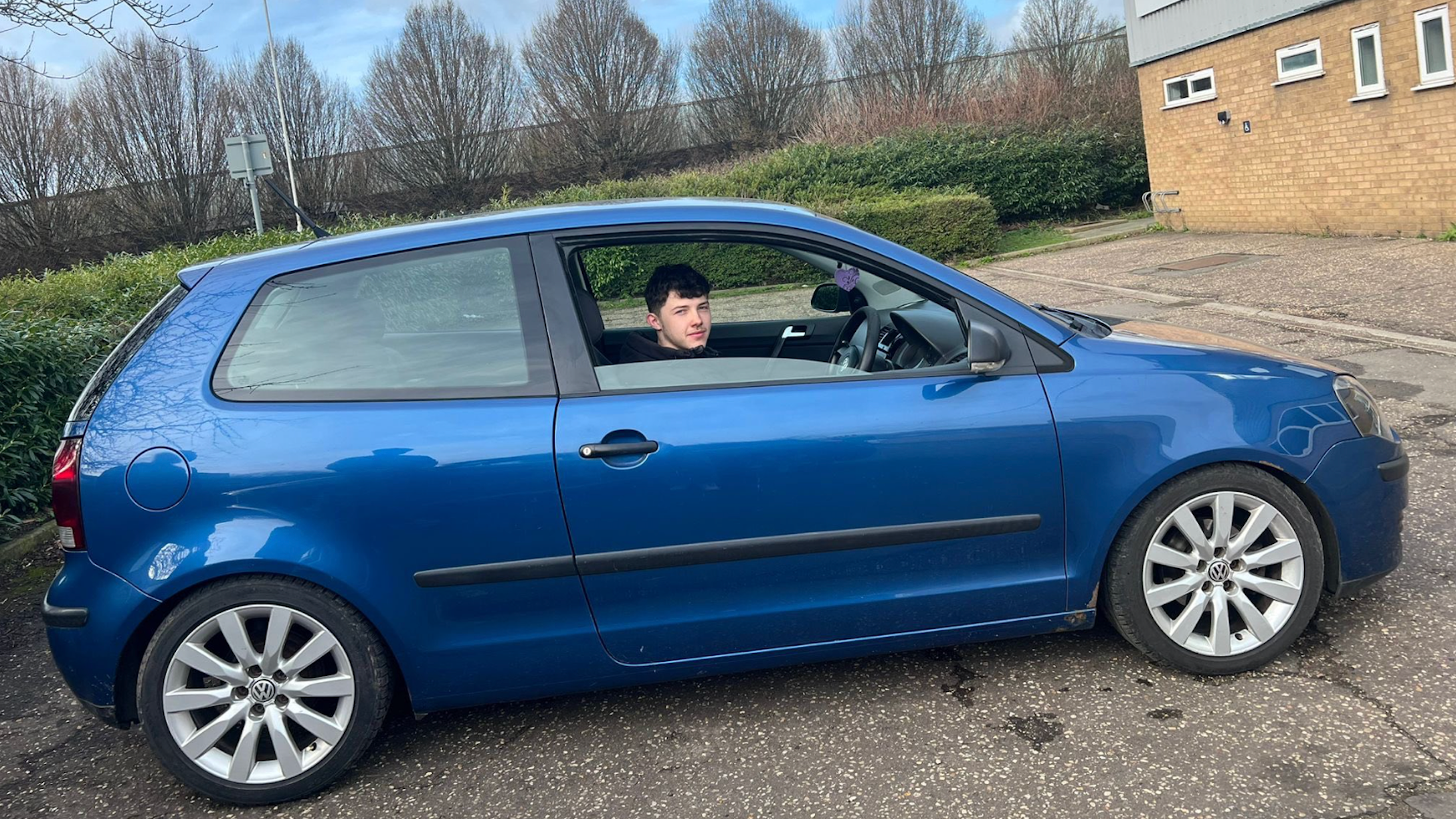 Declan Berry in the driver's seat of a blue hatchback