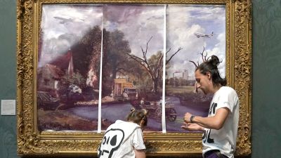 Protesters from Just Stop Oil climate protest group, cover John Constable's The Hay Wain with their own picture at the National Gallery, London.