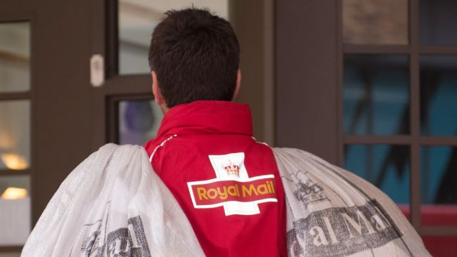 A Royal Mail employee carrying two bags of post over his shoulders.