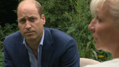Prince William listening to a woman talking