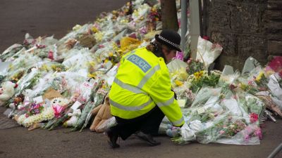 A police officer laying flowers at Dunblane Primary School, where 16 children and teacher Gwen Mayor were murdered by gunman Thomas Hamilton on March 13 1996.