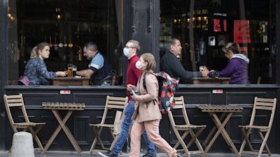 Coronavirus - Tue Sep 22, 2020
People wearing protective face masks walk past a bar in Edinburgh city centre, after First Minister Nicola Sturgeon announced a range of new measures to combat the rise in coronavirus cases in Scotland.