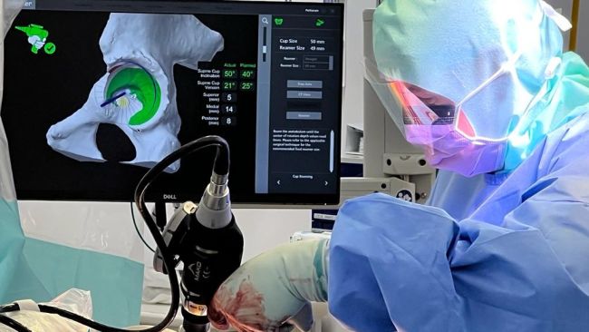 Surgeon Tim Petheram uses a surgical robot during a hip replacement