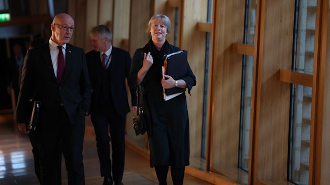 First Minister of Scotland John Swinney, walks with Finance Secretary Shona Robison as she arrives to announce the draft Budget for 2025-26 to MSPs at the Scottish Parliament in Holyrood, Edinburgh. Picture date: Wednesday December 4, 2024.