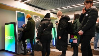 280222 People queue to take money out at an ATM in St Petersburg, AP