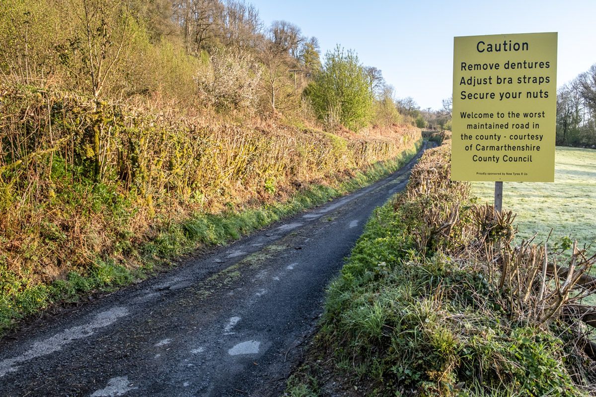Sign on potholed road in Carmarthenshire tells drivers to 'remove dentures'  and 'adjust their bras