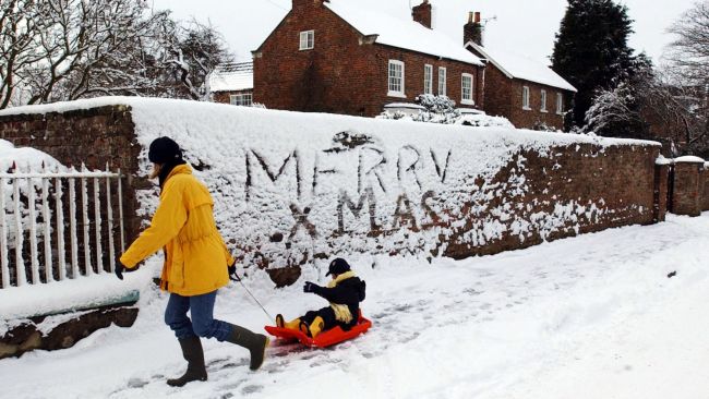 Family and friends enjoy the seasonal weather as they pass a festive message on the wall, in Husthwaite near Easingwold, as further heavy snowfalls in the area made a white Christmas almost certain. * With only two days to go to December 25, the PA WeatherCentre said there was a 90% chance of a white Christmas, with Scotland and northern England the most likely.  John Giles/PA