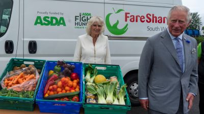 The Duke and Duchess of Cornwall pose beside a grocery display at the Asda distribution centre in Avonmouth in Bristol