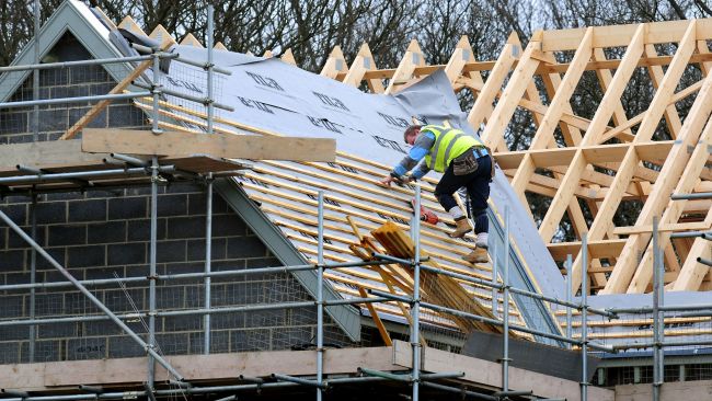 File photo dated 28/2/12 of a general view of roof workers building new houses in Derbyshire. The number of new homes being registered was a third (