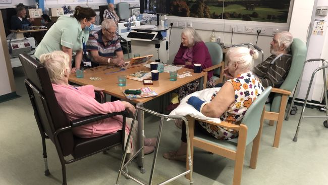 Elderly patients sit around a table with staff at The Ready to Leave unit at Taunton's Musgrove Park