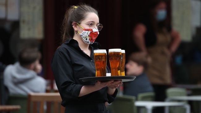 A server carries a tray of drinks from a pub in the Grassmarket in Edinburgh, as beer gardens, non-essential shops, restaurants and cafes, along with swimming pools, libraries and museums in Scotland reopen today after lockdown restrictions have eased. Picture date: Monday April 26, 2021. Andrew Milligan/PA 