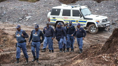 Police officers arrive at the mine where 21 people died in South Africa.