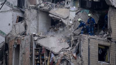 Rescue workers clear the rubble from an apartment building that was destroyed in a Russian rocket attack