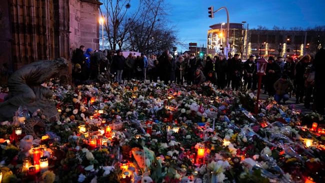 Crowds gather to pay tribute to the victims of an attack in Magdeburg.