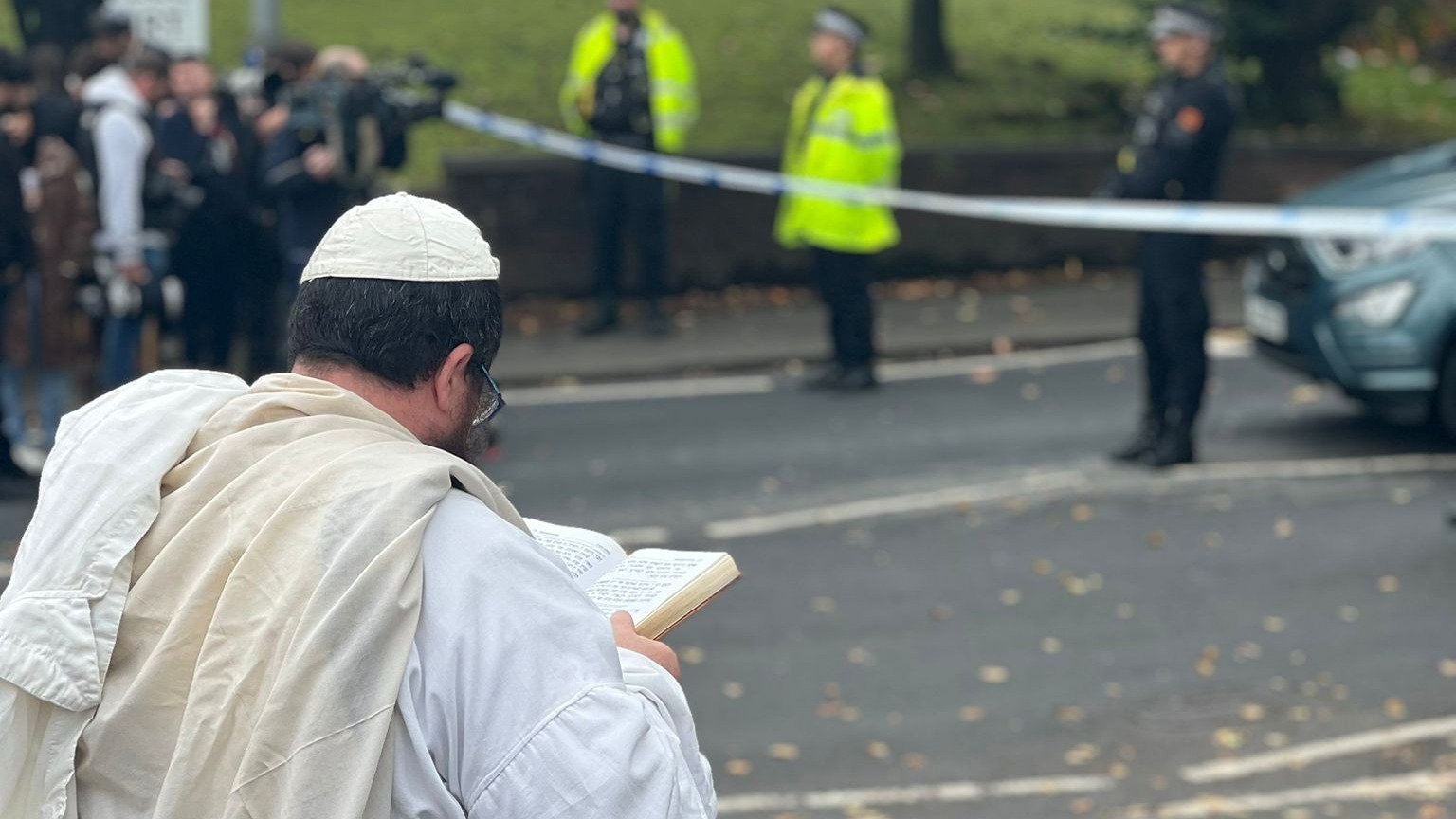 A man prays at the scene after two people killed in a suspected terror attack outside a synagogue in Manchester. 