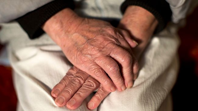 An elderly person's hands.