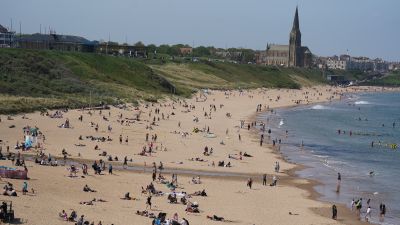 People enjoy the warm weather on Tynemouth Longsands beach, near Tynemouth in Tyne and Wear. 