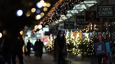 People walking through a shopping centre decorated with Christmas lights in London, in the final week of a four week national lockdown to curb the spread of coronavirus.
