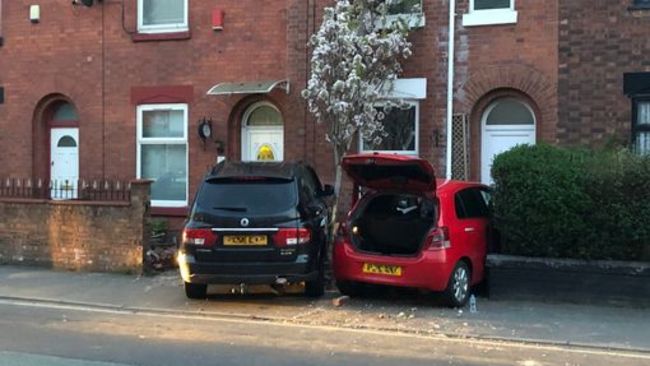 Two cars both end up in the same front garden after road collision