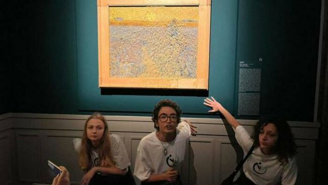 Protestors pictured in front of a Vincent van Gogh painting in Rome, after throwing a can of pea soup over it.