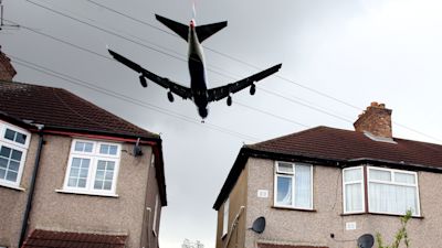 A generic photograph of a plane flying low over a local housing estate, on it's final approach to land on the Northern runway at Heathrow Airport
