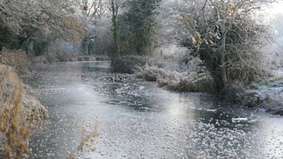 A layer of ice covers the Basingstoke Canal near Dogmersfield in Hampshire. Snow and ice have swept across parts of the UK, with cold wintry conditions set to continue for days. Picture date: Friday December 16, 2022.