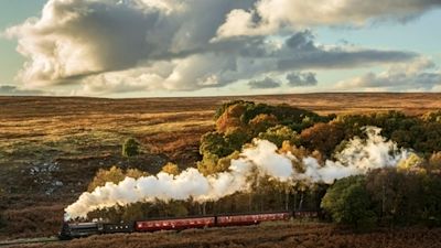 A 1264 locomotive locomotive travels through an autumn scene along North Yorkshire Moors Railway in the North York Moors National Park.