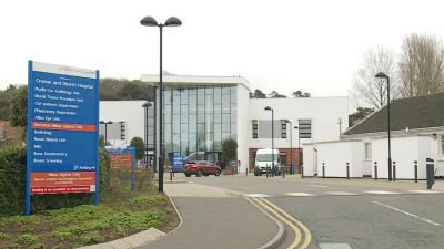 The outside of cromer hospital, a car and ambulance are parked outside