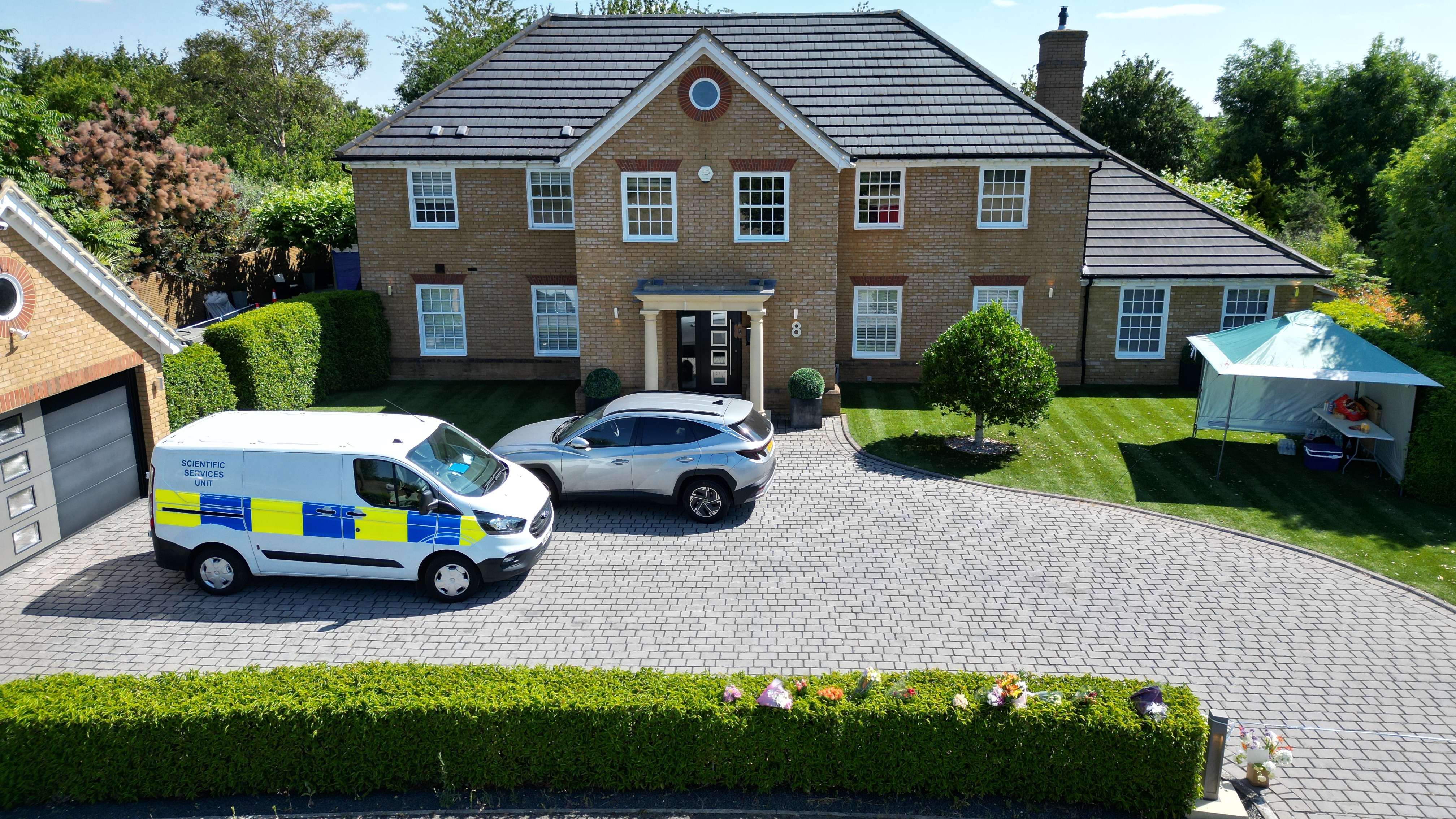 Police cars outside a large detached house
