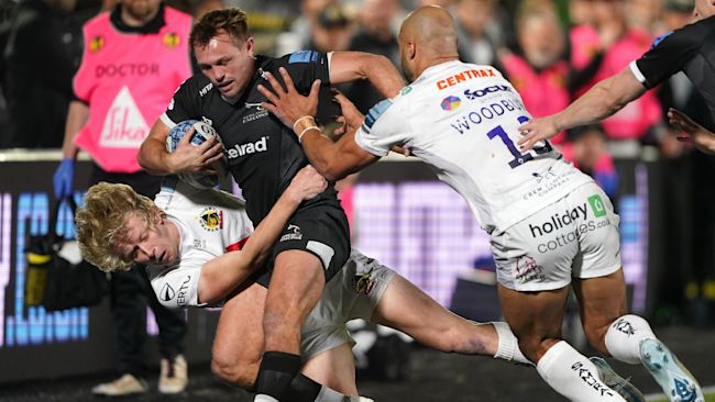 Exeter Chiefs' Josh Hodge (left) and Olly Woodburn tackle Newcastle Falcons' Sam Stuart during the Gallagher Premiership match at Kingston Park, Newcastle upon Tyne. Picture date: Friday October 18, 2024.