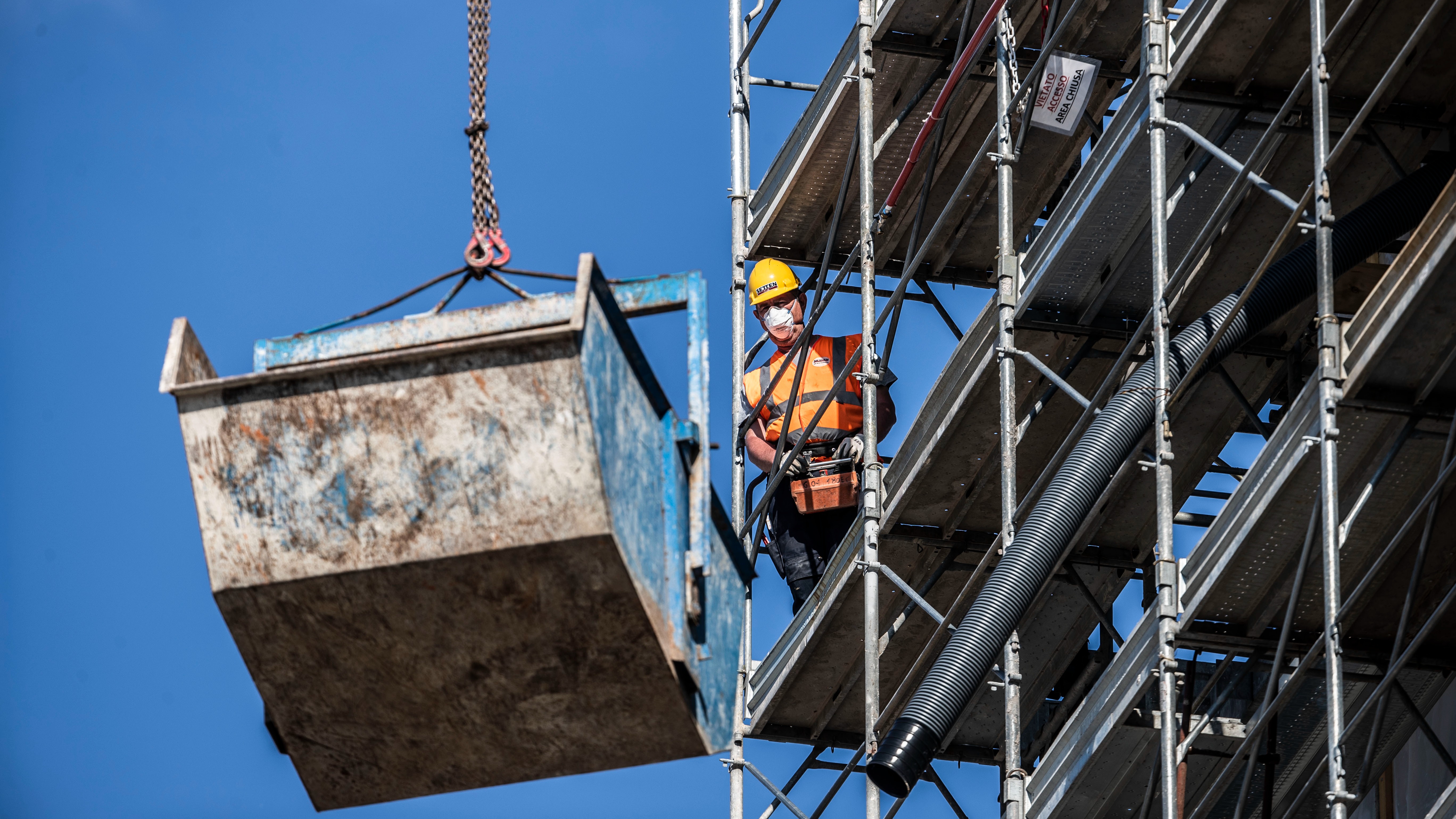 A worker operates at a construction site in Milan, Italy.