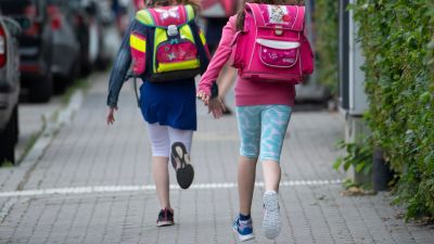 22 June 2020, Hessen, Frankfurt/Main: Two pupils from a primary school run the last few metres to the schoolyard with a satchel on their backs. Starting Monday, elementary school students in Hesse will again be allowed to attend classes together after months of restrictions. Photo: Boris Roessler/dpa

Credit: Boris Roessler / PA Images
(UK, Australian and New Zealand rights only)