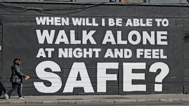 A member of the public walks past the latest mural by Irish artist Emmalene Blake in Dublin's city centre. The inscription 'When will I be able to walk alone at night and feel safe?' relates to violence against women in the wake of the death of Sarah Everard. Picture date: Monday March 29, 2021.