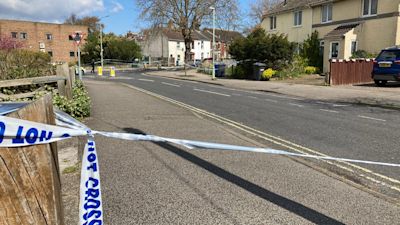 Police tape blocking off a street