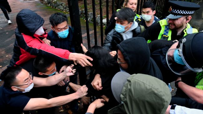 Hong Kong protester Bob Chan scuffles with people who are trying to drag him into the Chinese consulate in Manchester