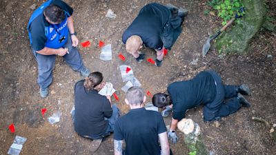 The specialist officers marking up an area of groundand taking items for further examination.