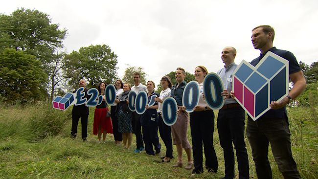 Staff and supporters holding up £2 million signs for the last push fundraising
