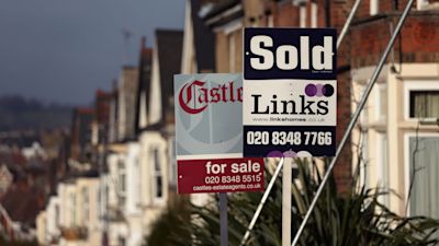 Sold and For Sale signs outside a row of houses in the UK.