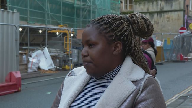 A still of Nonoe Nonkanyiso Tshuma speaking on the pavement outside of court.