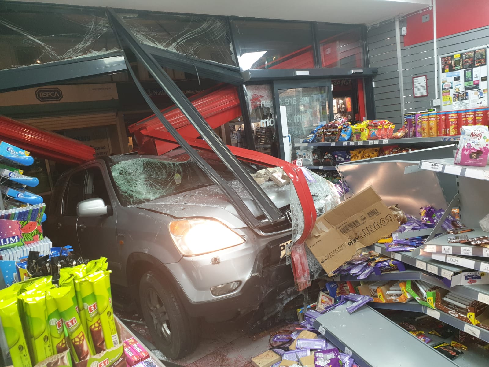 Car narrowly misses shoppers as it crashes into store in East Grinstead