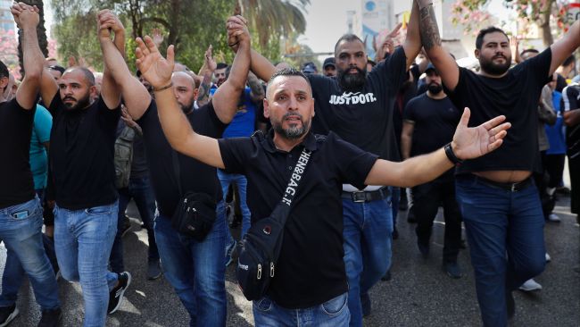 Supporters of the Shiite Hezbollah and Amal groups chant slogans against Judge Tarek Bitar.