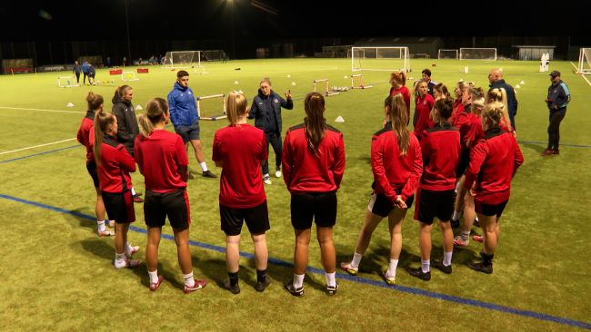 Exeter City women form circle around coach at training session