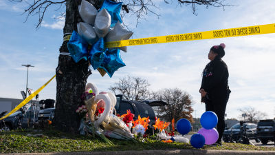 A woman stands at a vigil for the victims of a mass shooting at a Walmart store in the US.