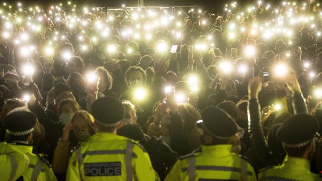 people in the crowd turning on their phone torches in Clapham Common, London, for a vigil for Sarah Everard