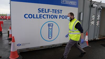 A Covid test kit is handed out at a Covid-19 Test Site at Edinburgh Airport , Scotland, where people have been asked to reduce their social contact as much as possible by meeting in groups of no more than three households. Picture date: Thursday December 30, 2021. Andrew Milligan/PA