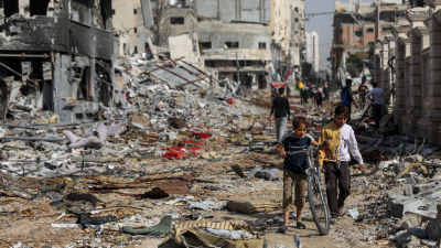 Palestinians walk through destruction in Gaza City.