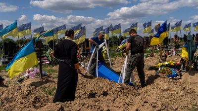 Undertakers lower the coffin of Ukrainian serviceman Oleksander Matyukhin, 32, in Kharkiv, eastern Ukraine,