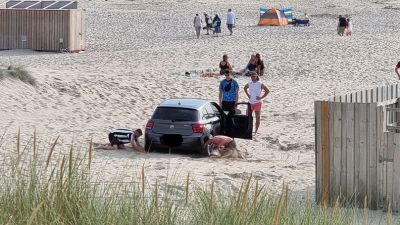 Beachgoers dig their car out of the sand in Cornwall. BPM Media/ Josh Munyard